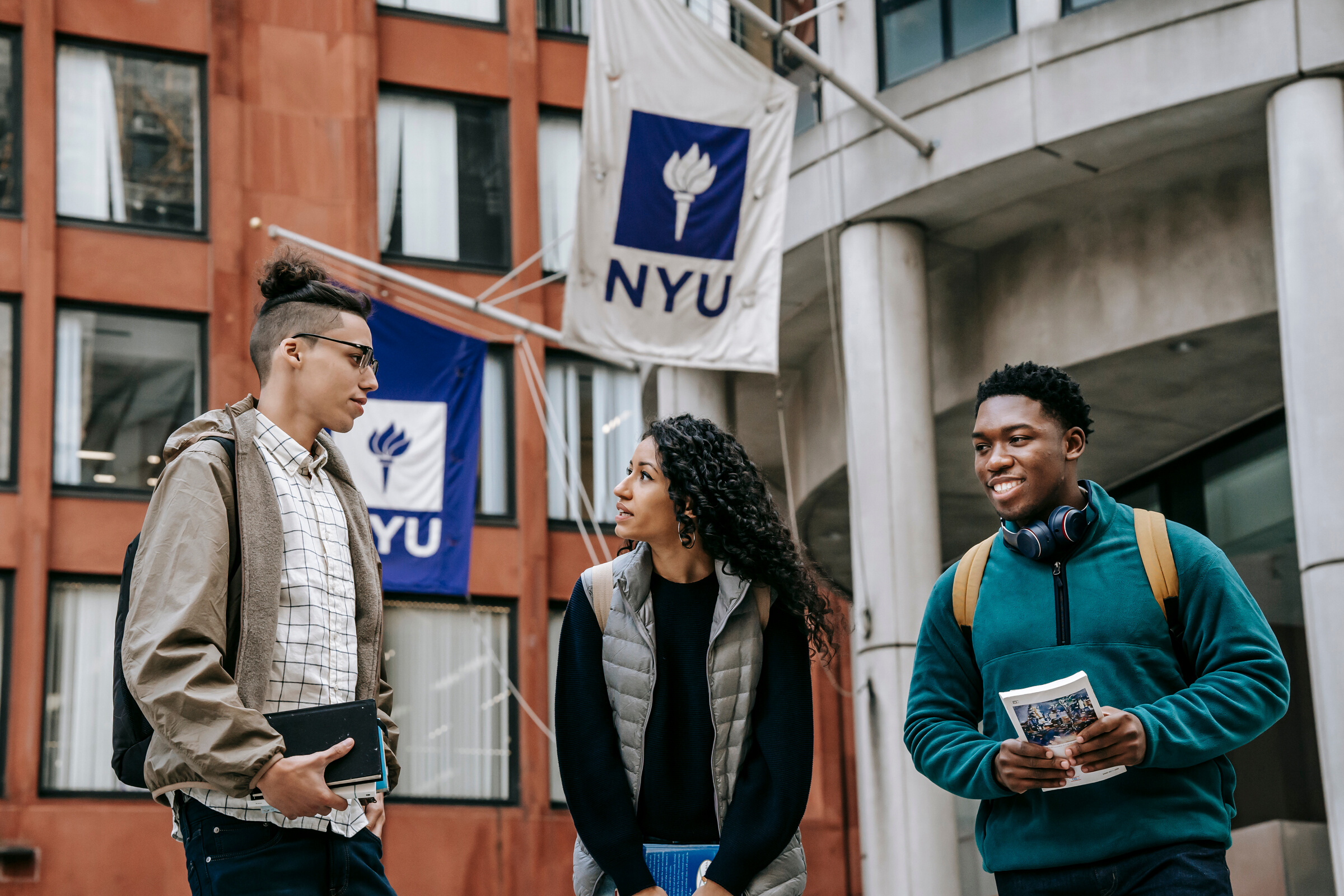 Multiethnic students standing near university together